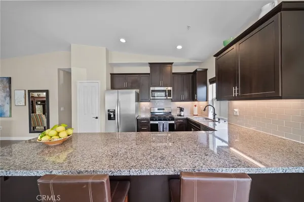 a kitchen with stainless steel appliances granite countertop a sink stove and refrigerator