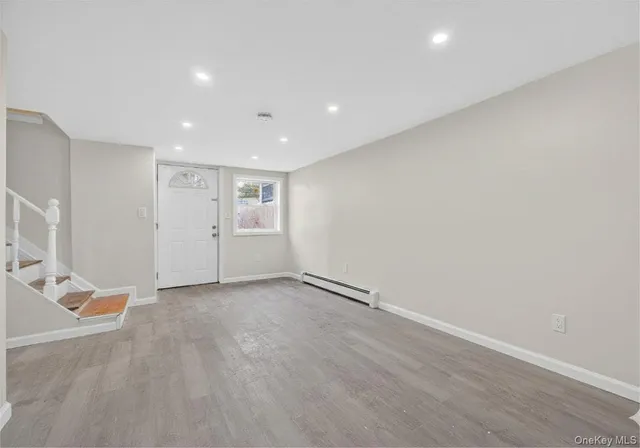 an empty room with wooden floor and stairs