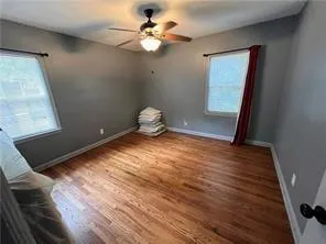 a view of a room with wooden floor and ceiling fan