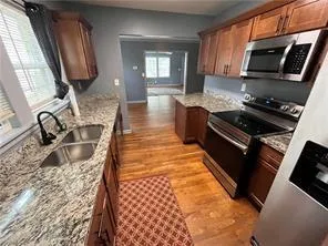 a kitchen with stainless steel appliances granite countertop a sink stove and microwave