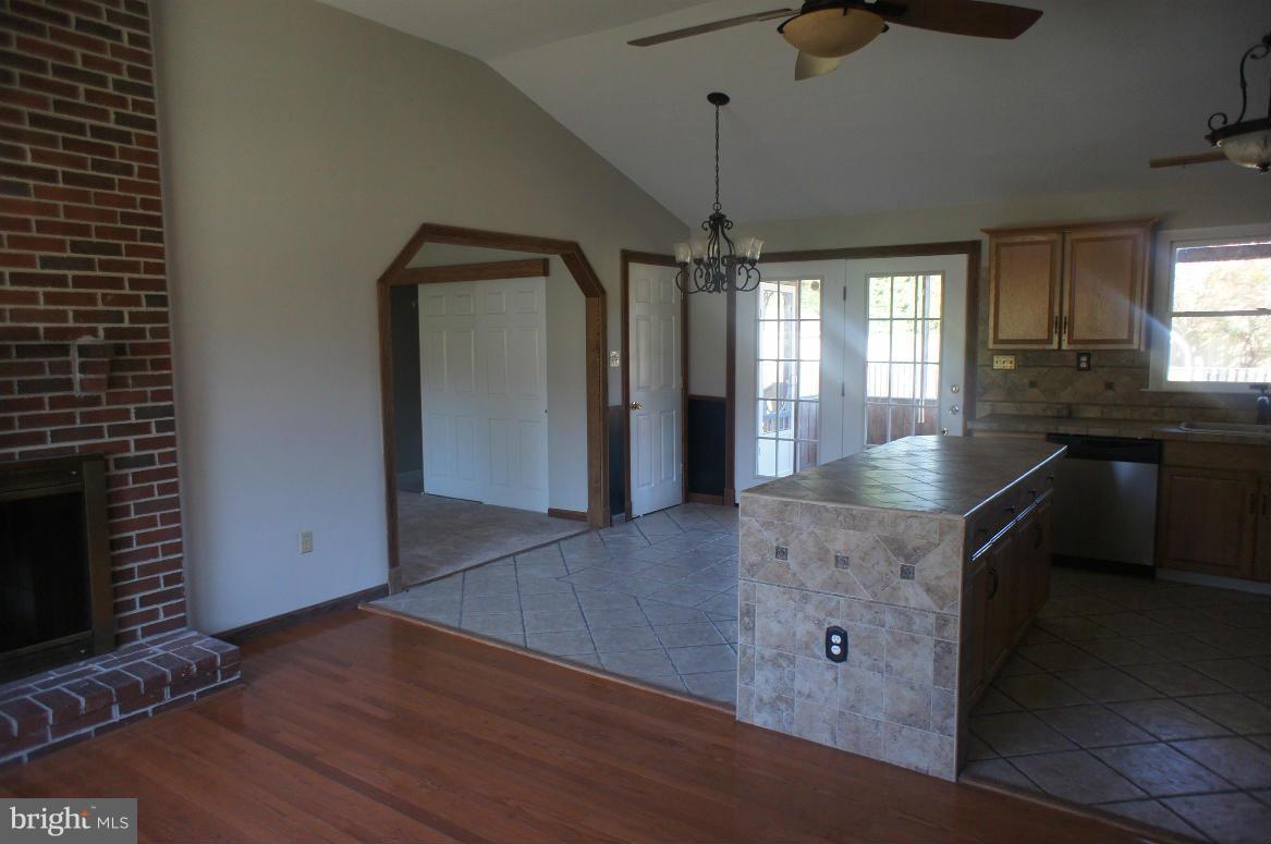 3042 Soper Road Huntingtown, MD 20639 - Photo 8 of 15 a kitchen with granite countertop a stove and a wooden floor