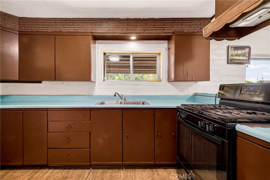 351 2nd Street Hamilton City, CA 95951 - Photo 16 of 52 a kitchen with granite countertop a stove a sink and wooden cabinets