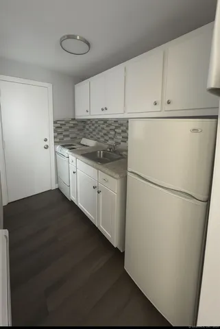 a kitchen with refrigerator and cabinets