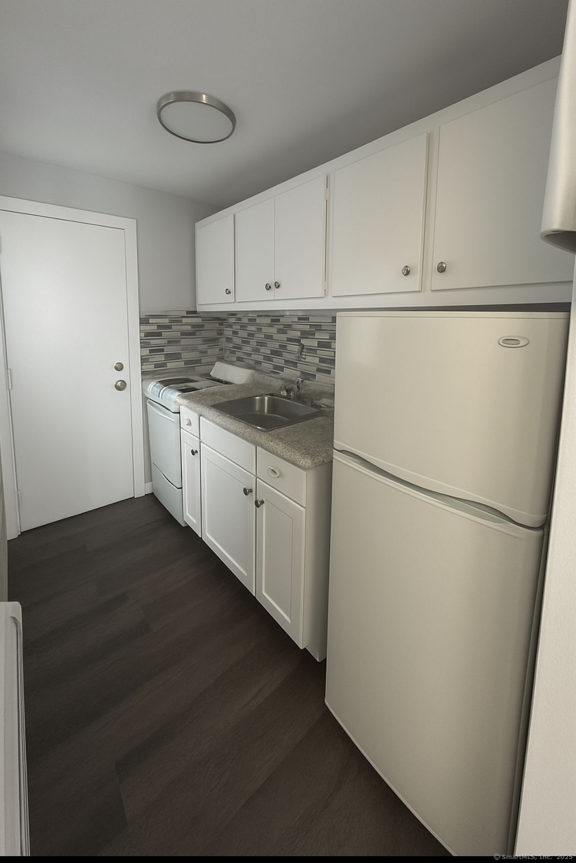 a kitchen with refrigerator and cabinets