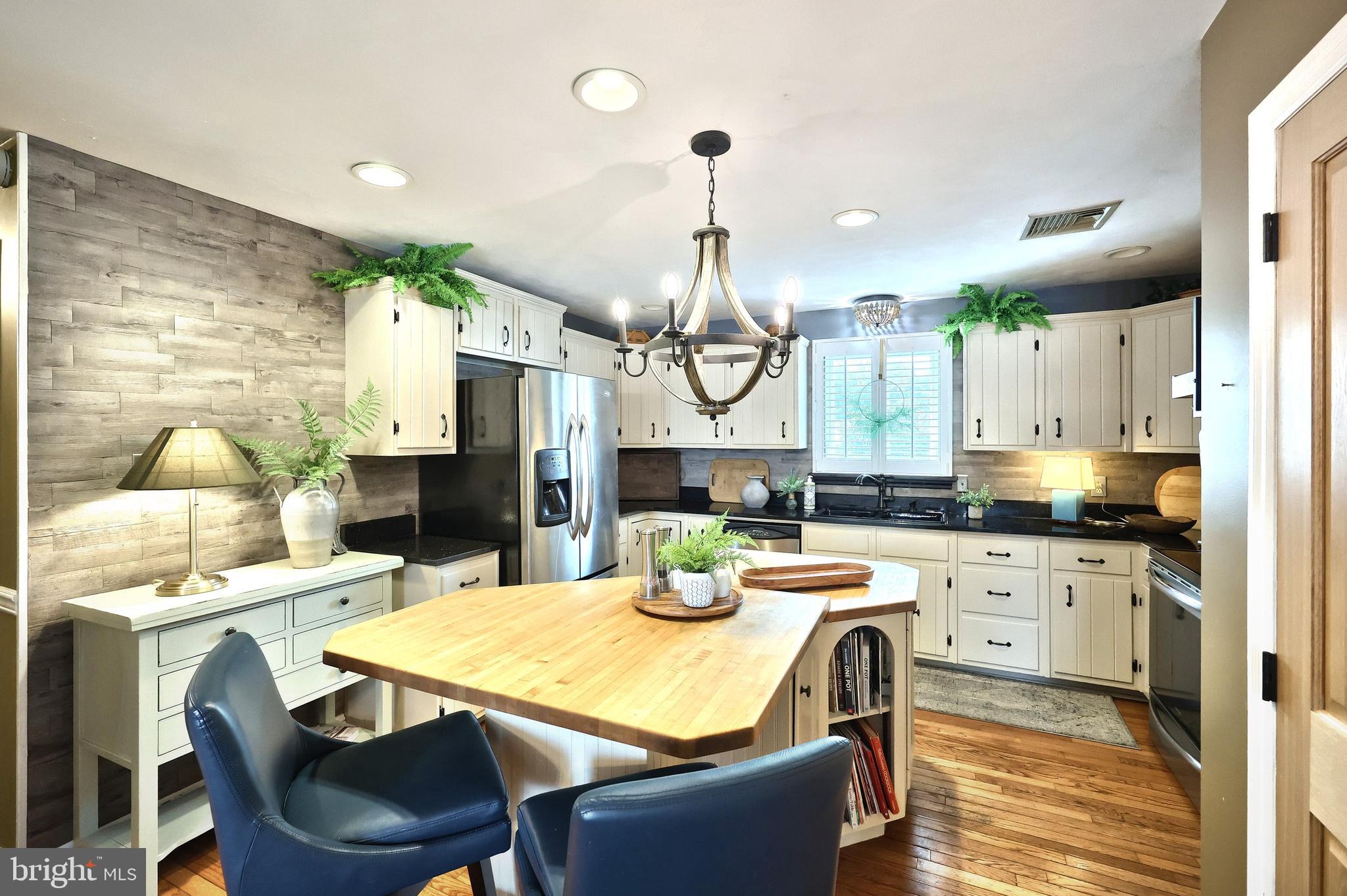 372 Maple Avenue Hanover, PA 17331 - Photo 39 of 87 a kitchen with stainless steel appliances granite countertop a sink a stove a dining table chairs and chandelier
