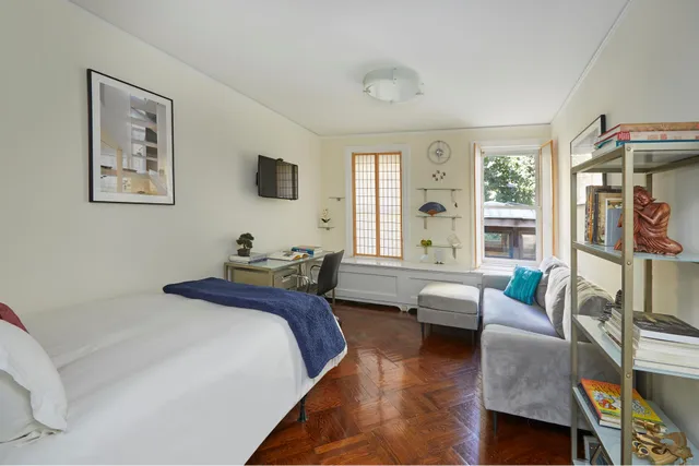 a bedroom with a bed couch and a window