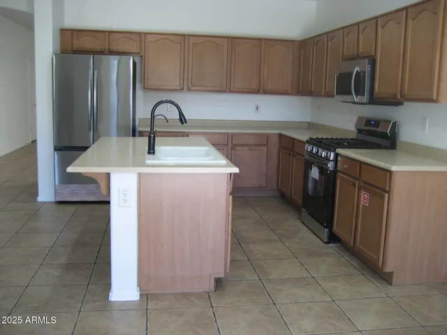 a kitchen with stainless steel appliances granite countertop a sink stove and microwave