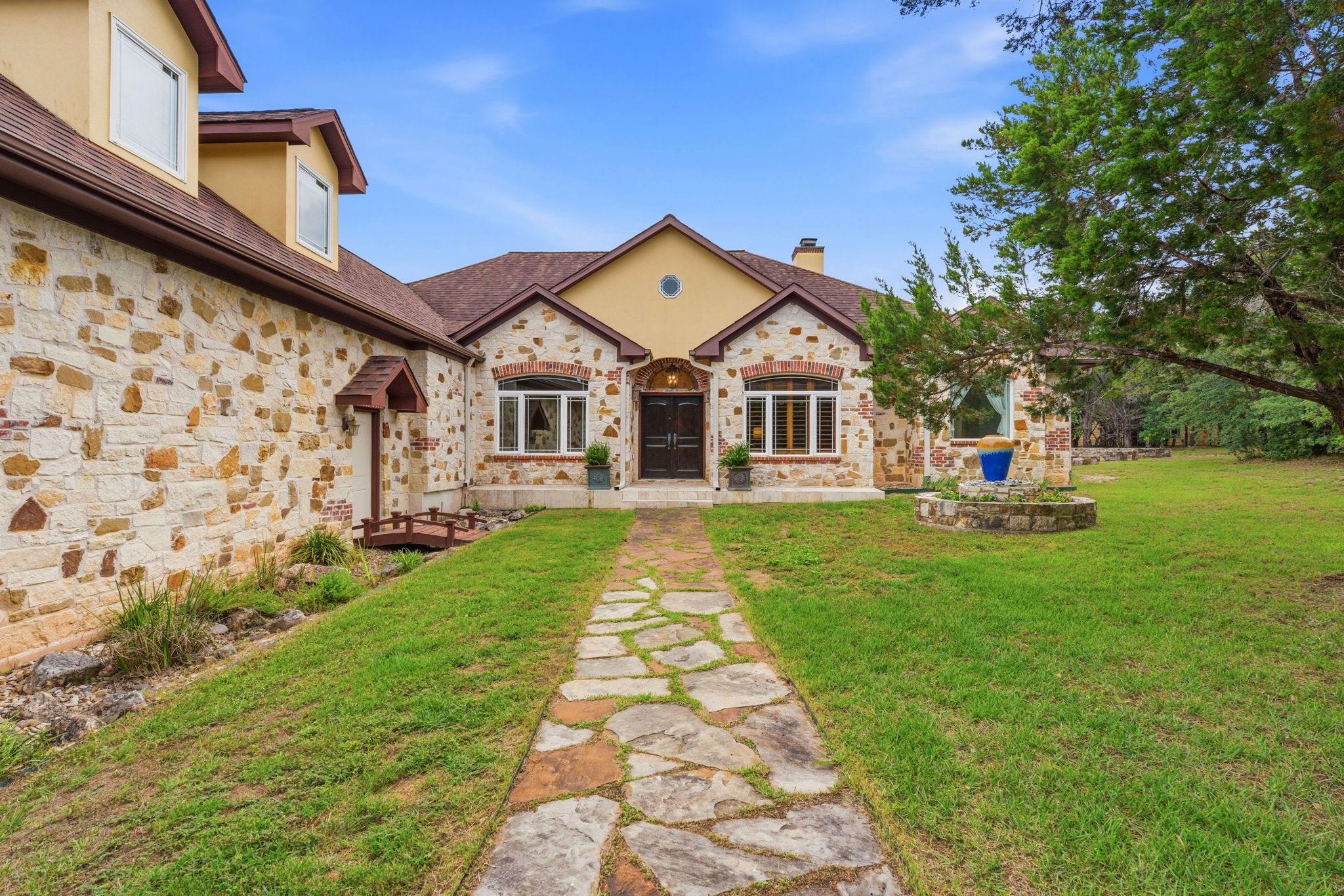 8121 Bluff Trail Austin, TX 78737 - Photo 33 of 40 A winding stone path leads to a grand stone and stucco facade, welcoming you home.