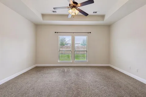 an empty room with a window and a fan