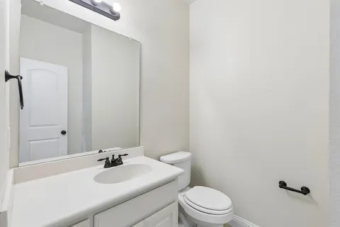 a bathroom with a sink a toilet and mirror