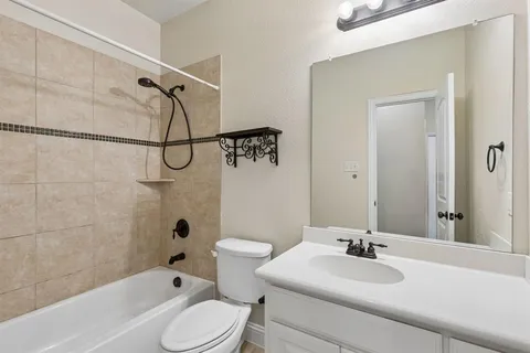 a bathroom with a granite countertop sink toilet a mirror and shower