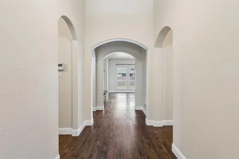 a view of a hallway with wooden floor