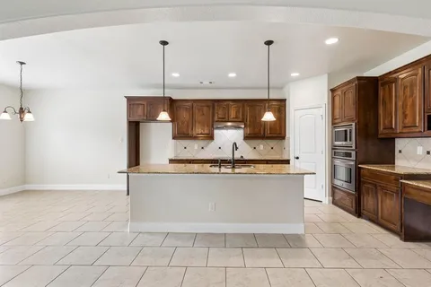 a kitchen with stainless steel appliances granite countertop a sink a stove a microwave and a refrigerator
