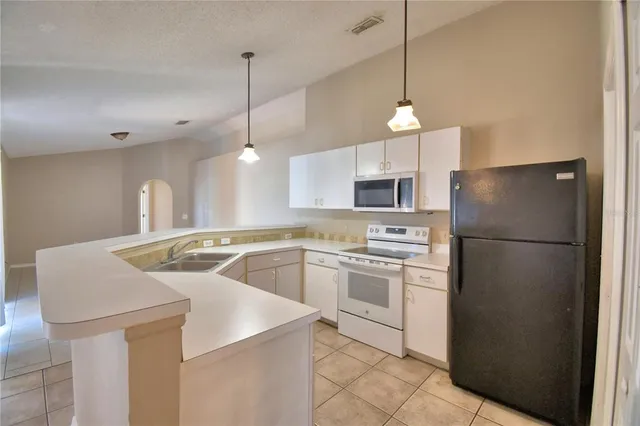 a kitchen with refrigerator and white cabinets