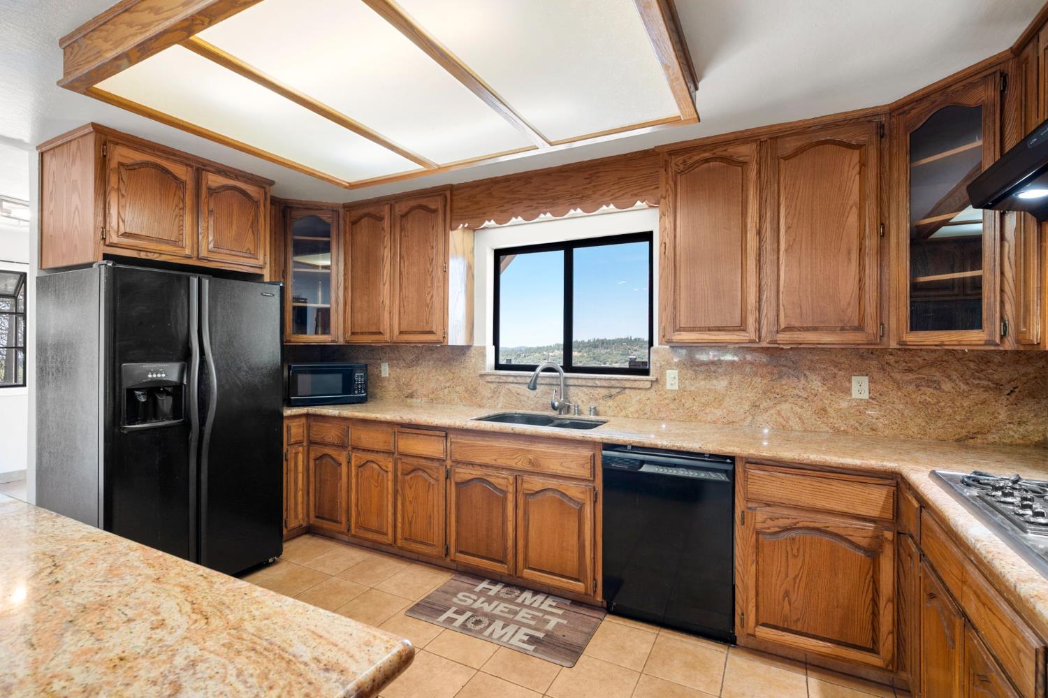 24835 Shake Ridge Road Volcano, CA 95689 - Photo 20 of 79 a kitchen with stainless steel appliances granite countertop a refrigerator a sink dishwasher a stove with wooden cabinets and floor