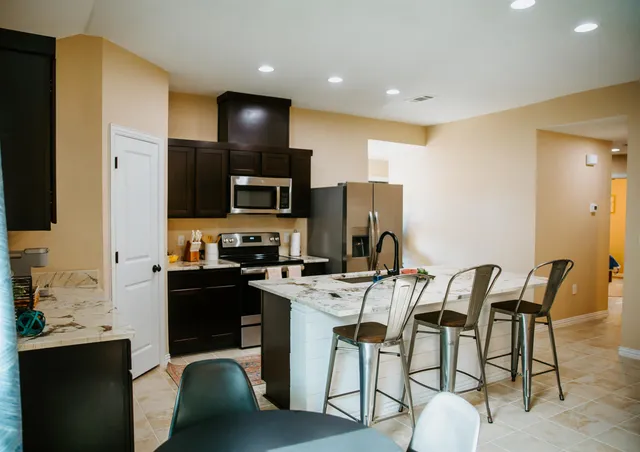 a kitchen with a table chairs refrigerator and microwave