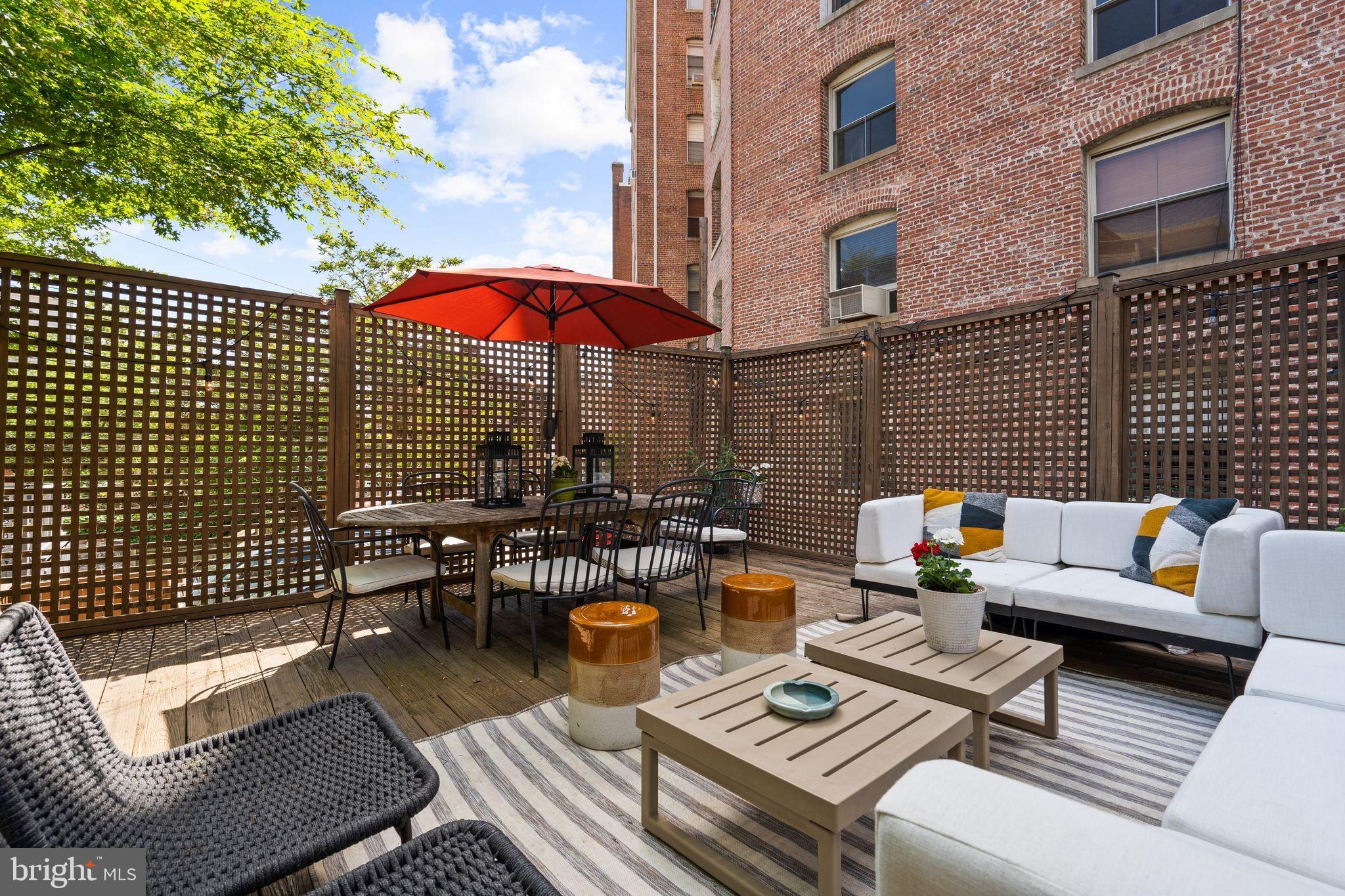 2026 15th Street Northwest Washington, DC 20009 - Photo 41 of 47 a view of a patio with couches table and chairs under an umbrella