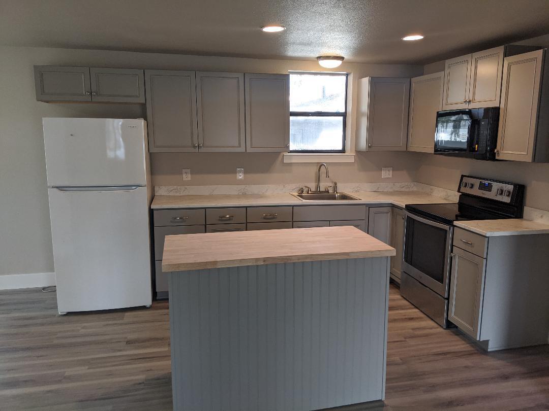 1012 State Street Redding, CA 96001 - Photo 7 of 23 a kitchen with a sink a stove a refrigerator and cabinets