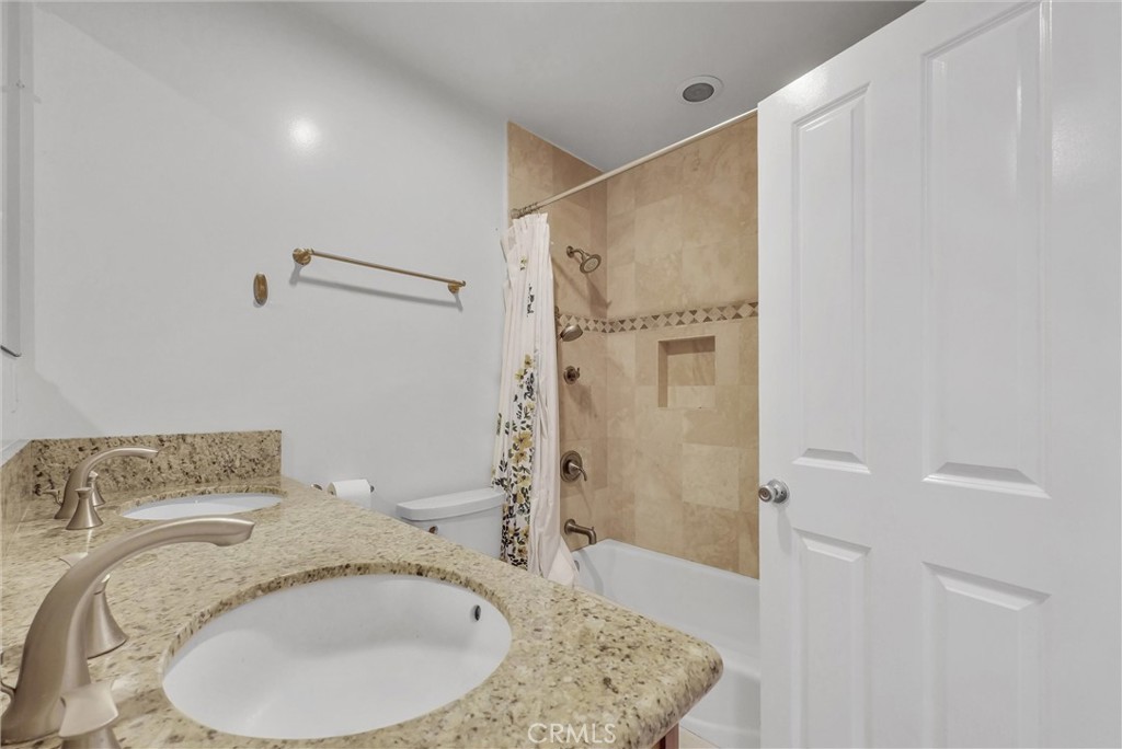 4741 Hazelbrook Avenue Long Beach, CA 90808 - Photo 17 of 22 a bathroom with a granite countertop sink a mirror and shower