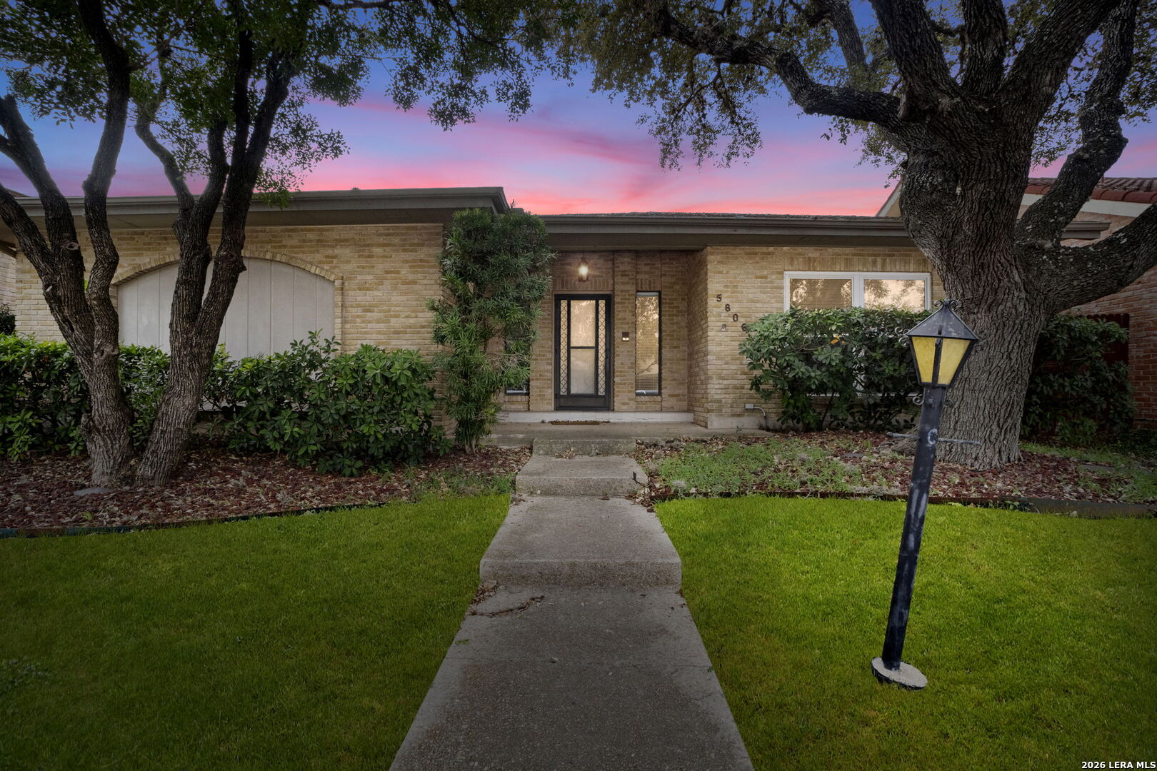 a front view of a house with a garden and yard