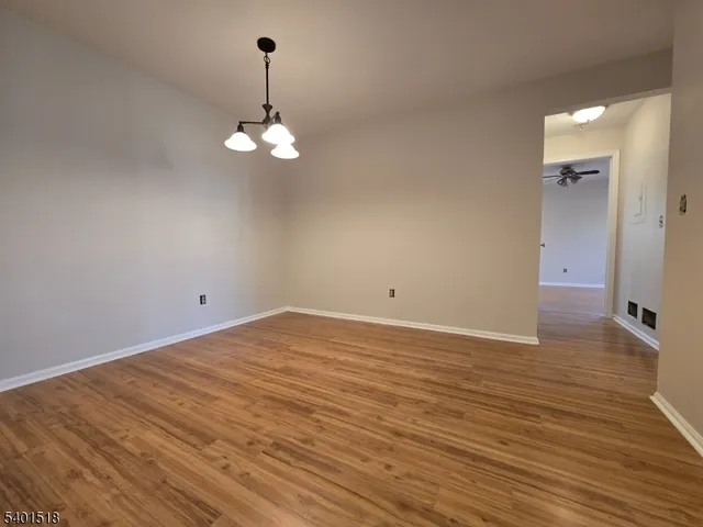 a view of a room with wooden floor and chandelier