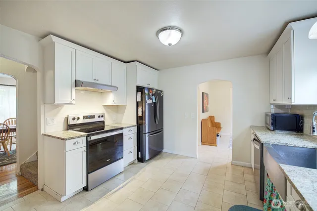 a kitchen with stainless steel appliances granite countertop a stove a refrigerator and a sink