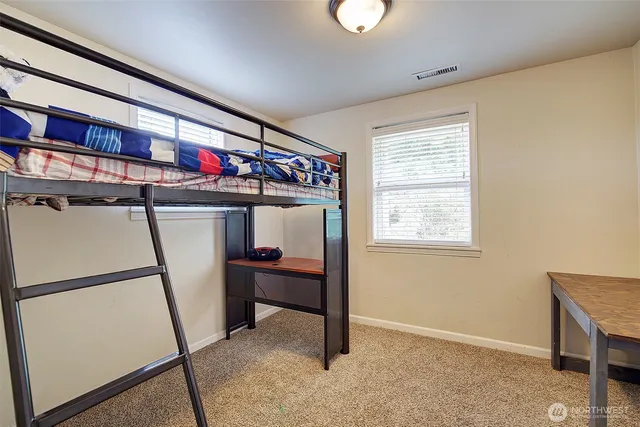 a very nice looking room with a dining table a window and potted plant