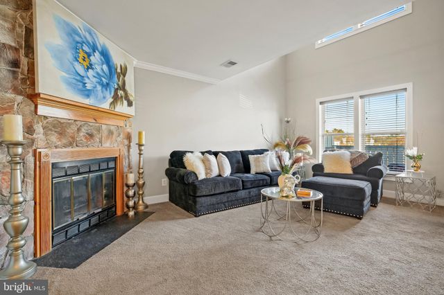 a living room with furniture a fireplace and a large window