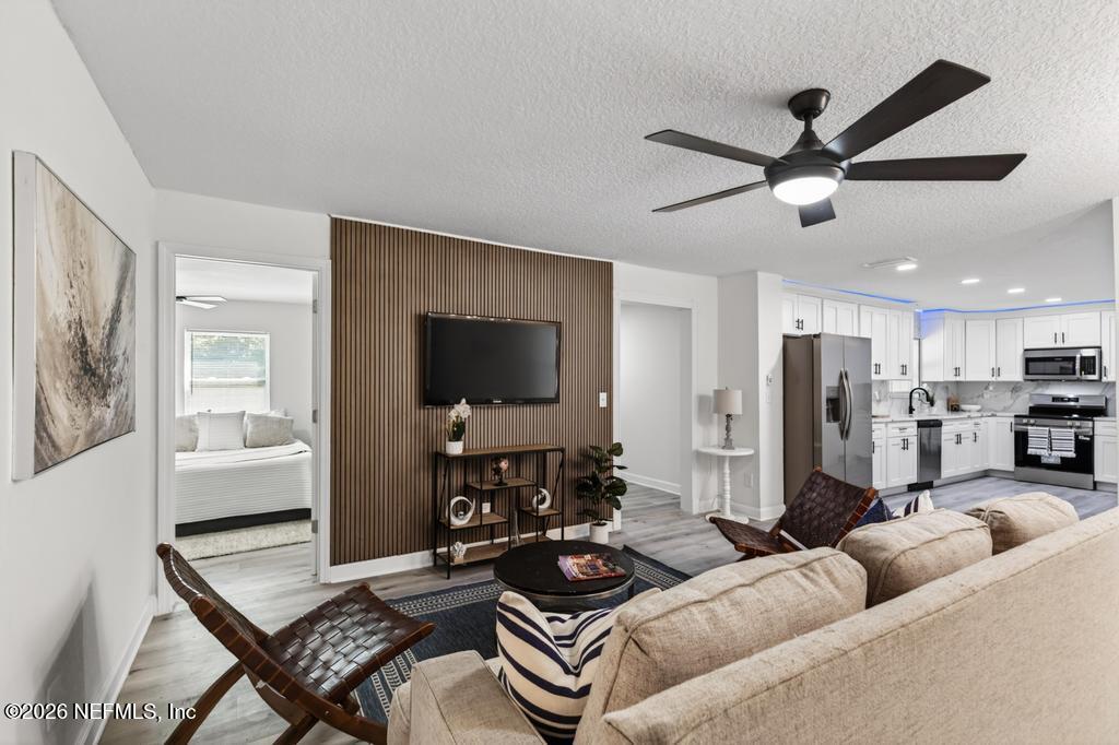 433 Lena Street St. Augustine, FL 32084 - Photo 15 of 42 a living room with furniture and a flat screen tv with kitchen view