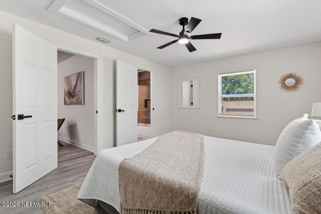 433 Lena Street St. Augustine, FL 32084 - Photo 29 of 42 a bedroom with a large bed chandelier and a window