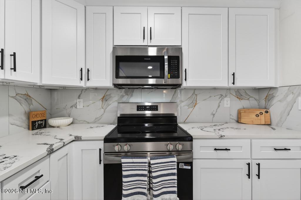 433 Lena Street St. Augustine, FL 32084 - Photo 8 of 42 a kitchen with a stove and a white cabinets