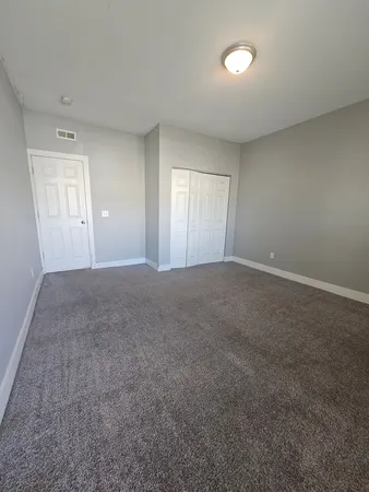 a view of a big room with windows and chandelier fan