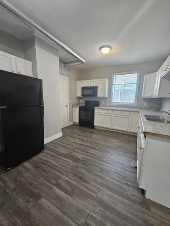 a kitchen with a refrigerator and a stove top oven