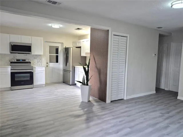 a view of kitchen with sink and refrigerator