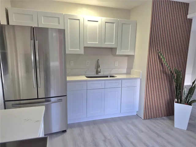 a kitchen with stainless steel appliances granite countertop white cabinets a stove a microwave and a window