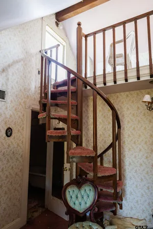 a view of staircase with wooden floor and chair