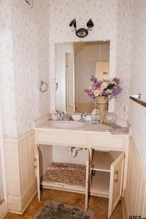 a bathroom with a granite countertop sink a mirror and shower
