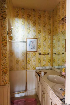 a bathroom with a vase of flowers