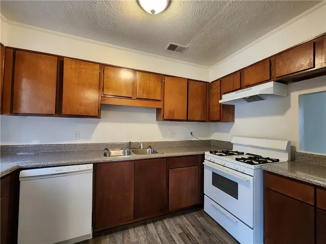 a kitchen with stainless steel appliances granite countertop a sink stove and cabinets