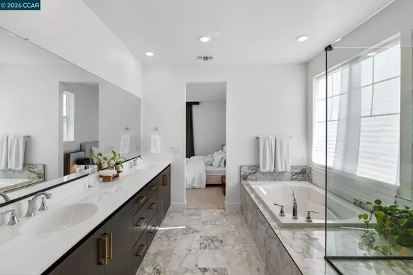 a bathroom with a double vanity sink a large mirror and shower