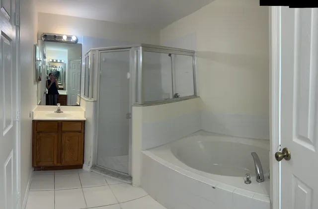 a bathroom with a bathtub a sink a vanity and a shower