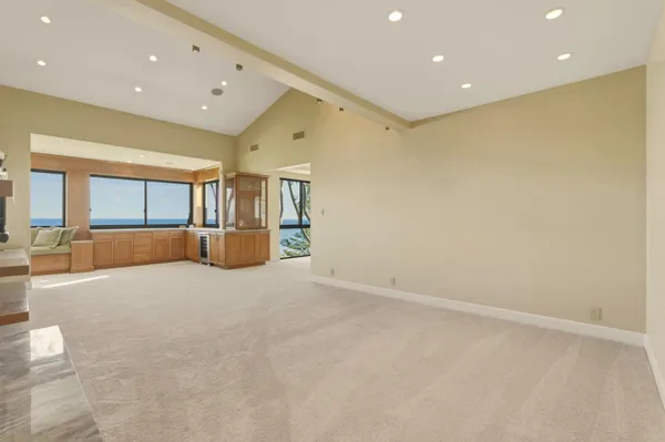 a view of a patio with couches and table and chairs under an umbrella with palm trees