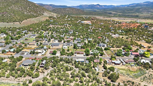 327 North Lodge Road Central, UT 84722 - Photo 44 of 45 Aerial perspective showcasing a residential community nestled among rolling, tree-covered hills