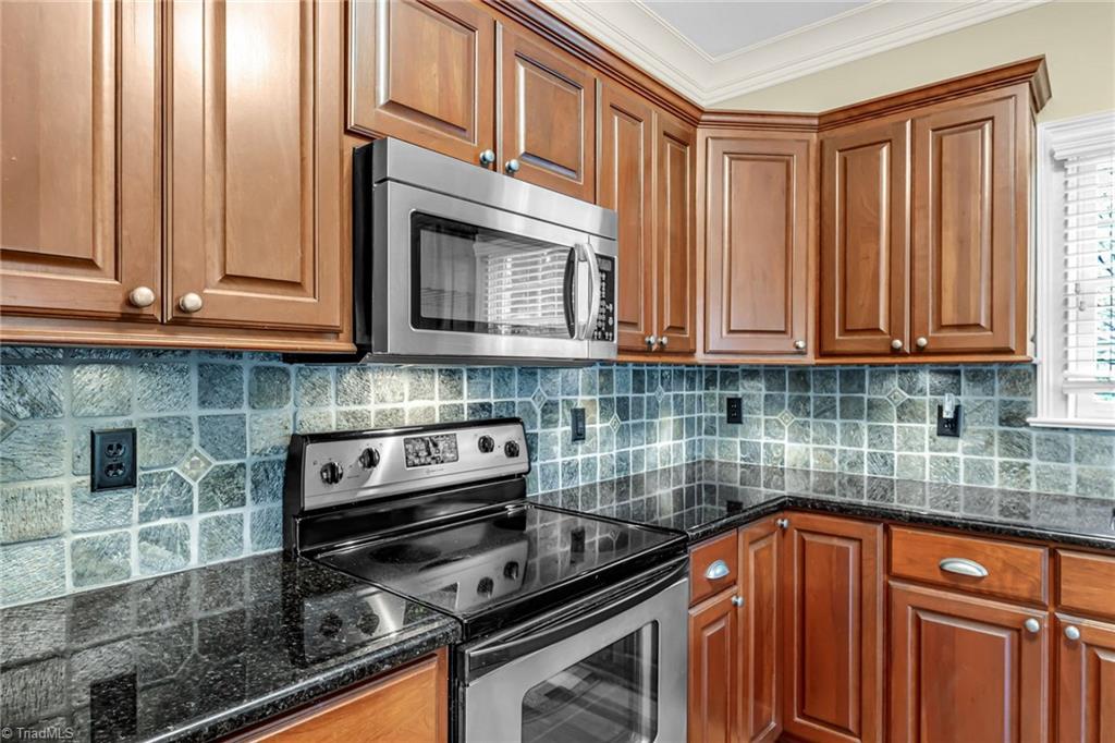 5909 Ballinger Road, Unit A Greensboro, NC 27410 - Photo 14 of 41 S/steel stove surrounded by tile backsplash and granite ctops