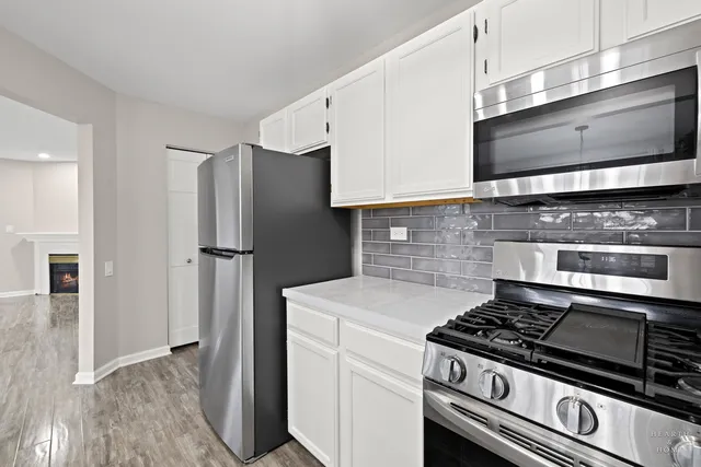a kitchen with stainless steel appliances a stove a microwave and cabinets
