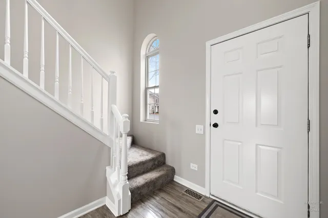a view of a hallway with wooden floor and entryway