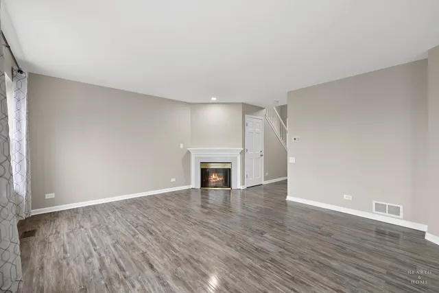 a view of a livingroom with wooden floor and a fireplace