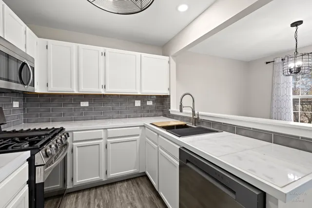 a kitchen with sink a microwave and cabinets