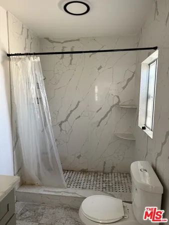 a bathroom with a toilet and a shower