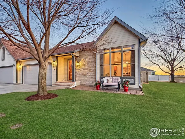 a view of a house with a big yard and large tree
